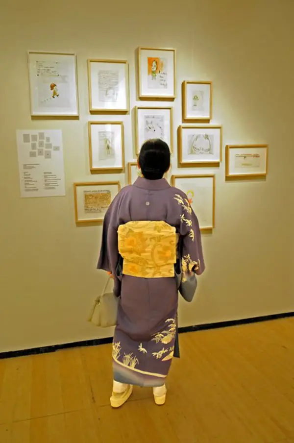 A visitor examining works of art on display at the Asia Society and Museum.