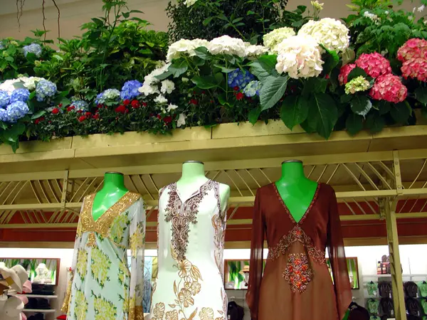 Three designer dresses on display inside of Macy's Herald Square.