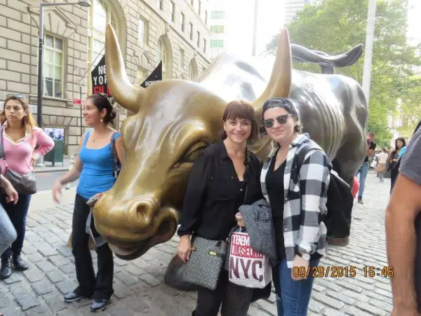 tourists bull sculpture downtown