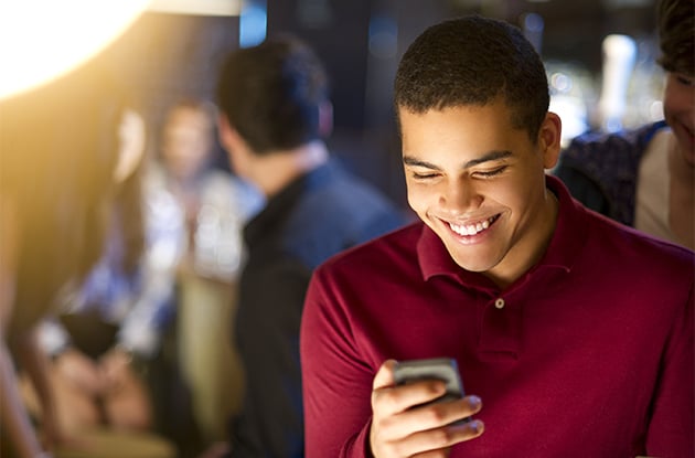 boy smiling while texting