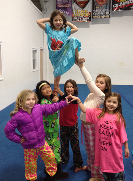 girls in pajamas cheerleading pose