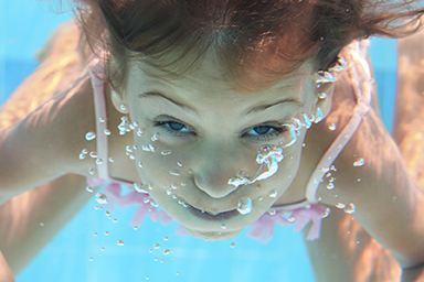 girl blowing bubbles underwater