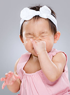 young girl sneezing