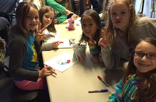young girls decorating CDs at party