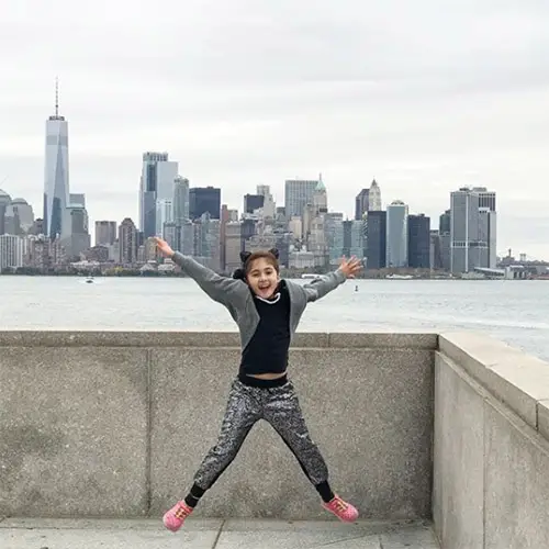 young girl jumping nyc skyline