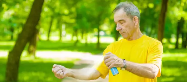 Man applying sunscreen while in a park
