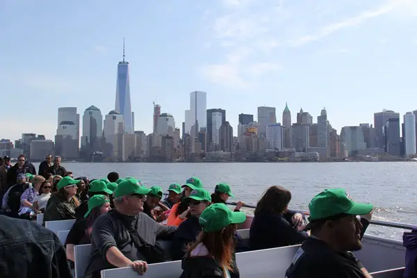 Passengers sitting on a Statue Cruise in the harbor.