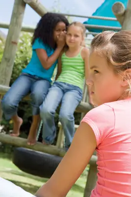 bullies; girls gossiping on the playground; girl being bullied