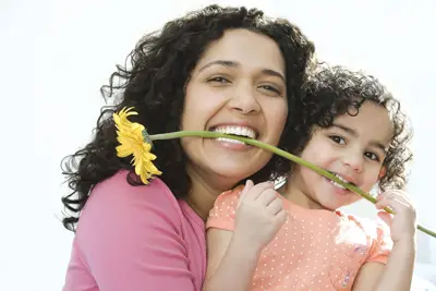 mom and daughter holding a flower