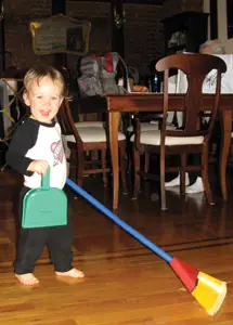 little boy having fun sweeping the floor