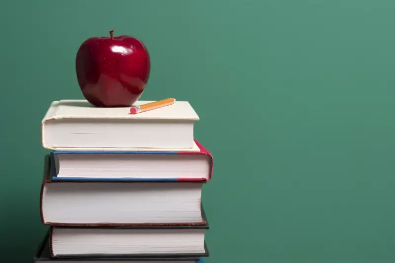 apple on top of school textbooks