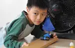 Boy Experimenting with Toy Car