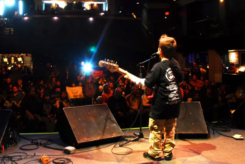 child playing guitar on stage