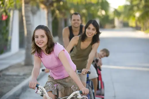 family riding bikes on street