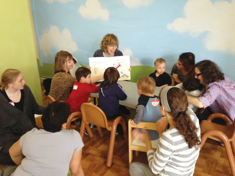 A teacher at GiGi's Playhouse teaching kids to read