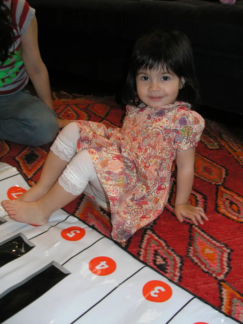 child playing floor piano